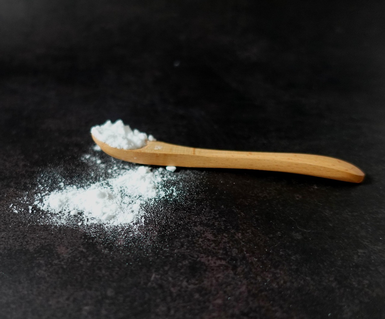 white powder and a wooden spoon